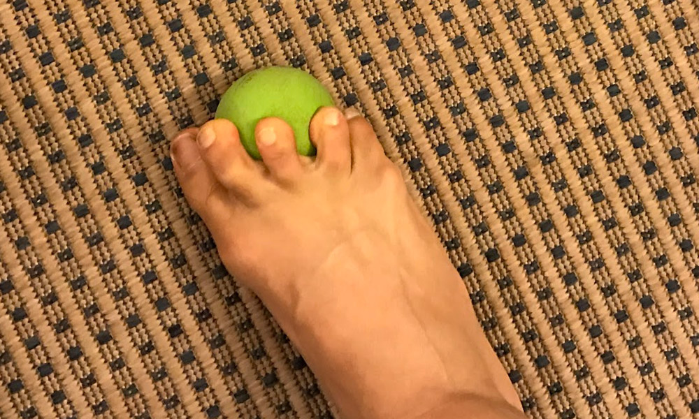 Toe stretch mobility exercise on Yoga Tune Up Ball.